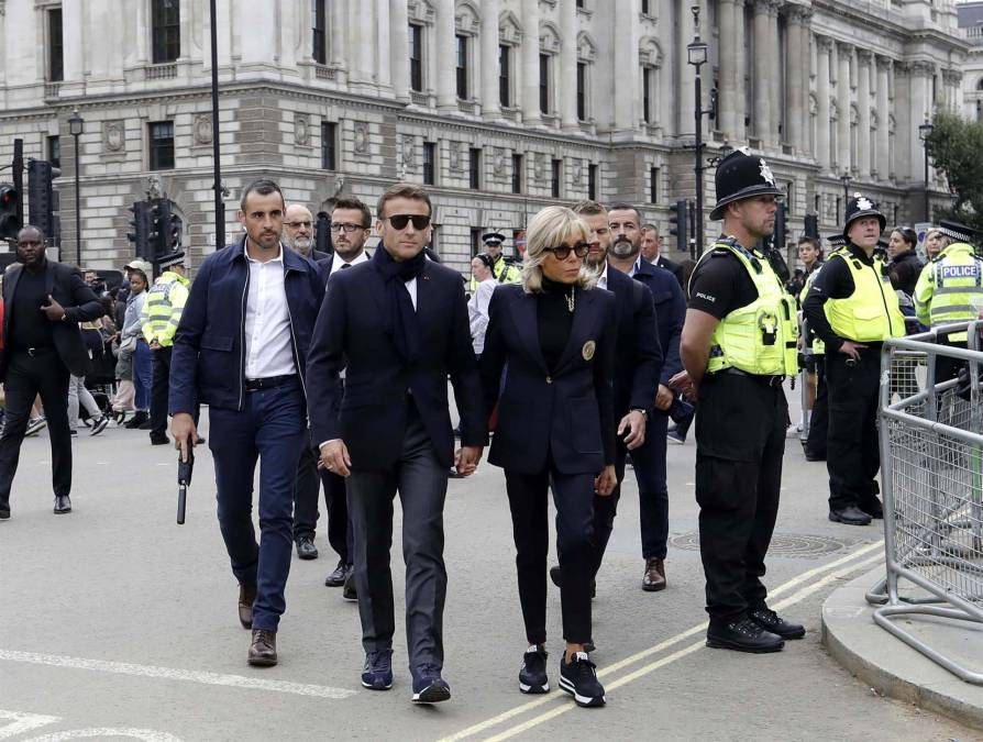 El presidente de Francia, Emmanuel Macron junto a su esposa, Brigitte, a su llegada a Londres rodeados por un equipo de seguridad.