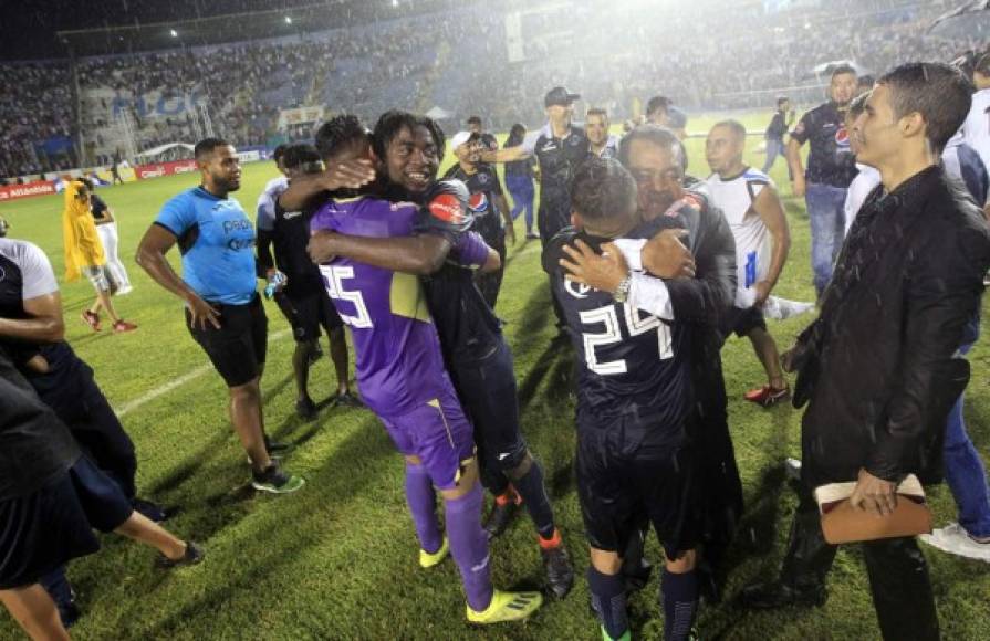 Los jugadores del Motagua celebrando en el campo y bajo la lluvia al final del partido.