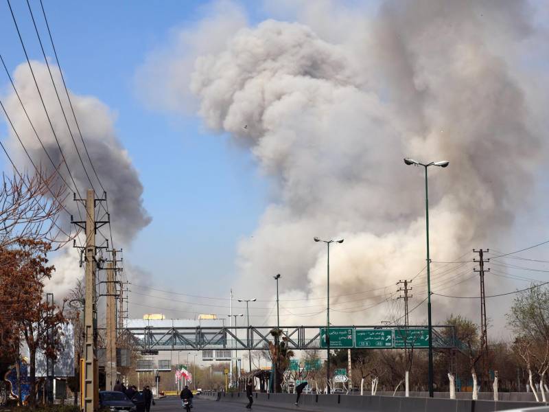 La gente corre en busca de refugio mientras el humo se eleva tras un ataque aéreo en el centro de Teherán, Irán, este jueves. Una operación militar conjunta israelí-estadounidense continúa atacando múltiples puntos de Irán desde la madrugada del 28 de febrero de 2026. EFE/ Abedin Taherkenareh