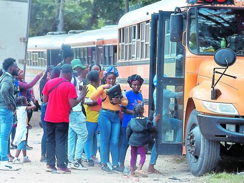 Migrantes de varias nacionalidades abordando buses cerca de la frontera entre Honduras y Nicaragua.