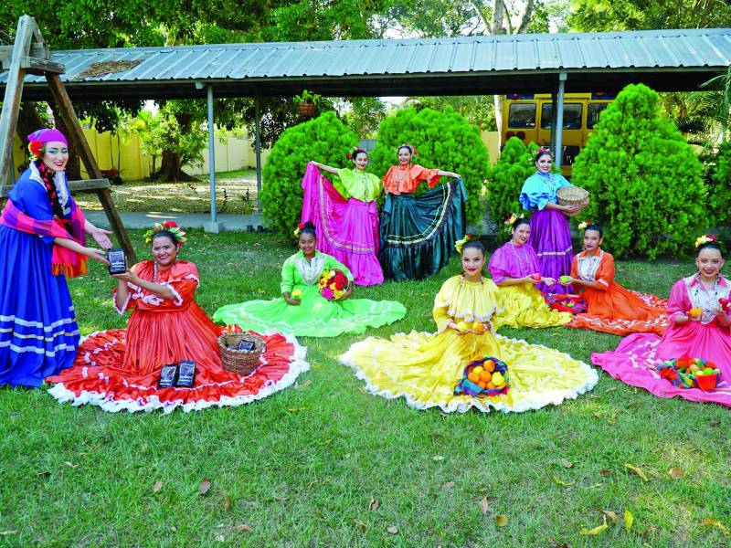 <b>Folclor.</b> En la fotografía, las bailarinas representan con sus coloridos vestuarios y accesorios un mercado tradicional de los pueblos de Honduras.