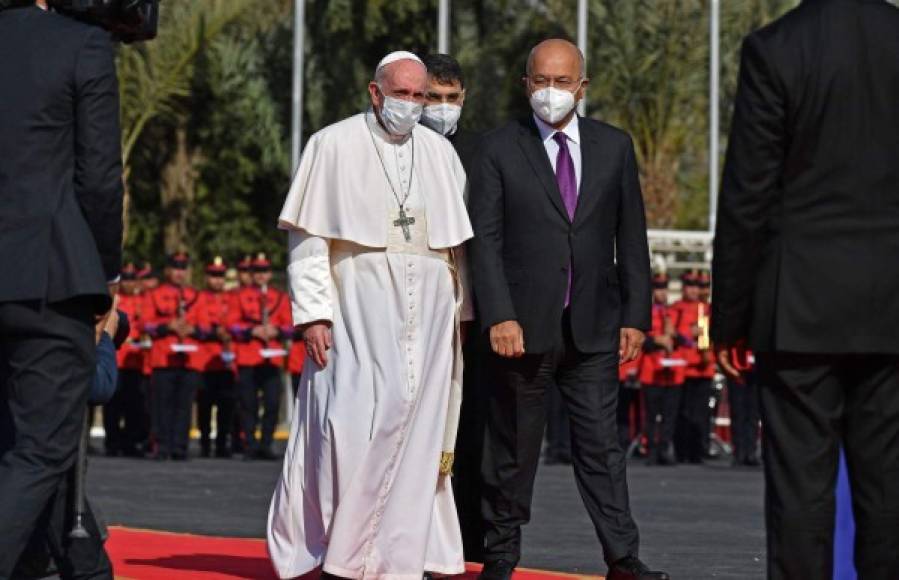 Iraqi President Barham Saleh (R) welcomes Pope Francis at the presidential palace in Baghdad's Green Zone on March 5, 2021 at the start of the first papal visit to Iraq. - Pope Francis landed in war-battered Iraq on the first-ever papal visit, defying security fears and the pandemic to comfort one of the world's oldest and most persecuted Christian communities. (Photo by Vincenzo PINTO / AFP)
