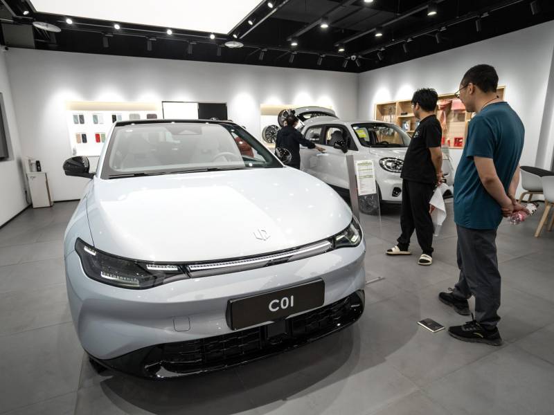 La gente mira vehículos eléctricos dentro de una sala de exposición de Leapmotor en Beijing, China. Imagen de archivo.