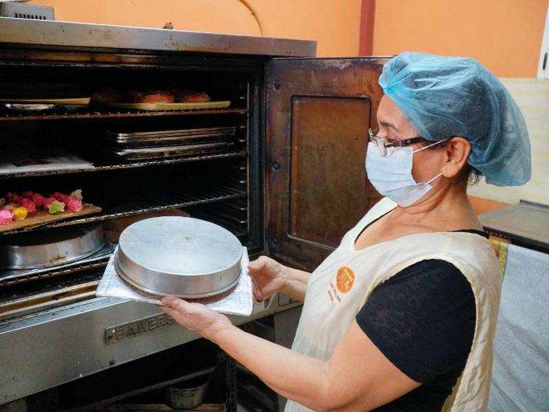 Mujer hondureña preparando una torta | Fotografía de archivo