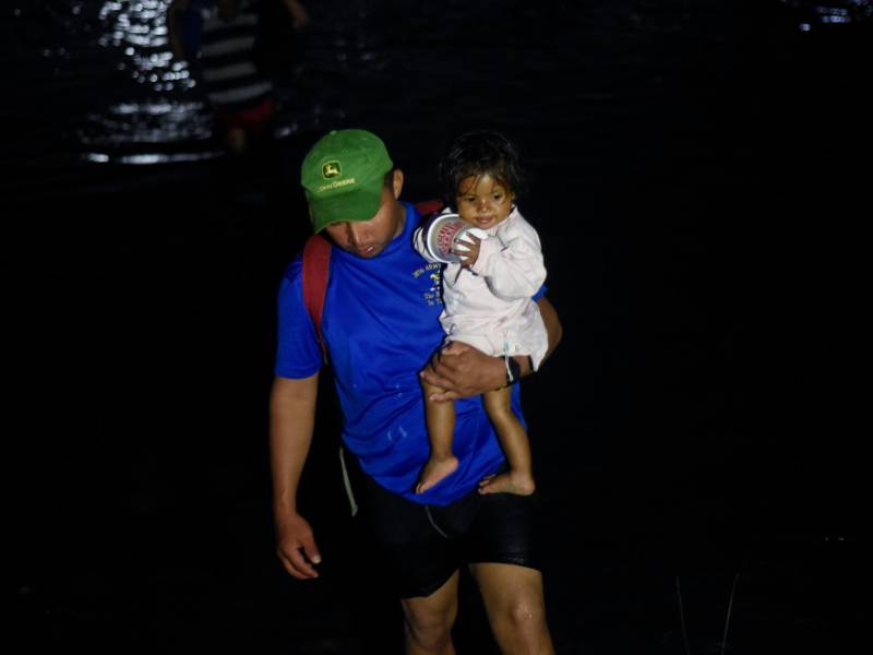Migrantes cruzan el río Suichate de regreso a Tecun Uman, luego de no poder ingresar a Ciudad Hidalgo, México.