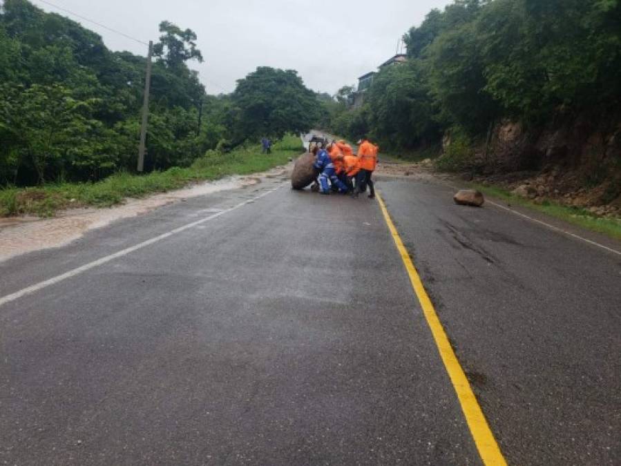 Agentes de la Policía de Tránsito y personal de la municipalidad de Santa Bárbara se unieron para despejar una gran roca que cayó hasta la mitad de la carretera.