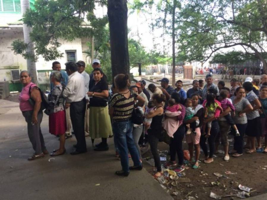 Decenas de mujeres cargado sus hijos s espera que abran las oficinas del RNP en San Pedro Sula.
