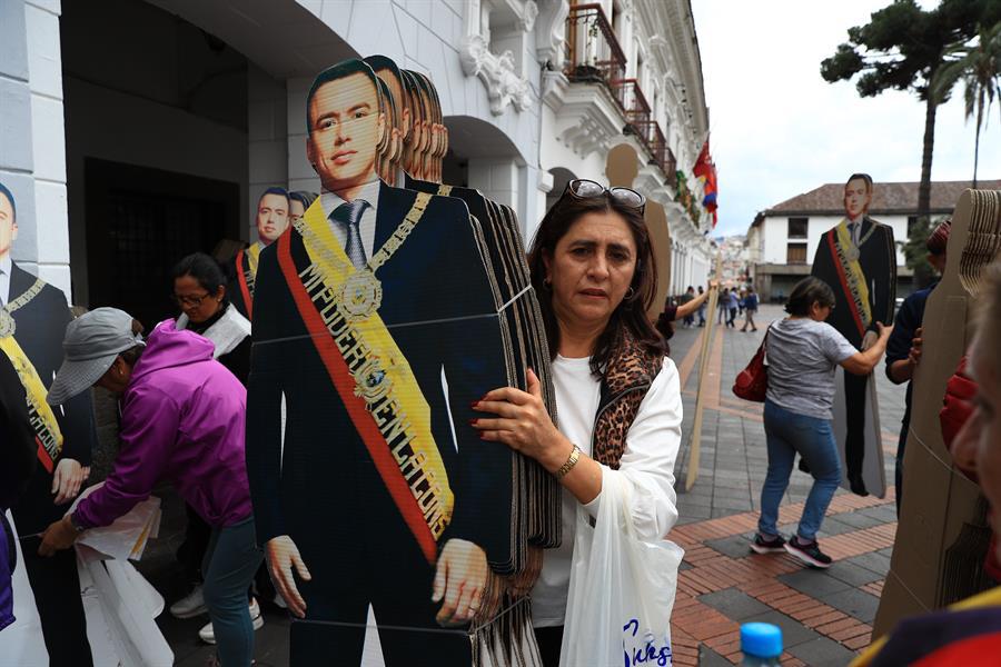 Una simpatizante del presidente de Ecuador, Daniel Noboa, sostienen figuras con la imagen de Noboa este domingo, afuera del Palacio de Gobierno en Quito.
