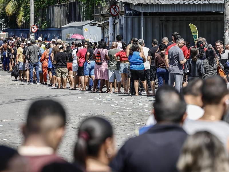 Personas hacen fila en un puesto de votación este domingo, en el barrio de Bonsucesso cerca al complejo de favelas de Maré, en Río de Janeiro (Brasil).