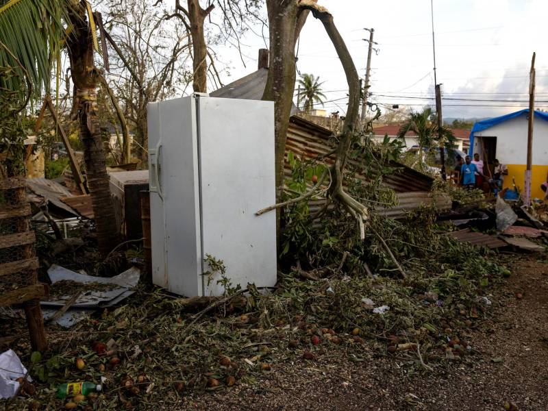 Una persona observa desde el techo de una casa afectada por el paso del huracán Melissa este jueves, en Santa Cruz (Jamaica).
