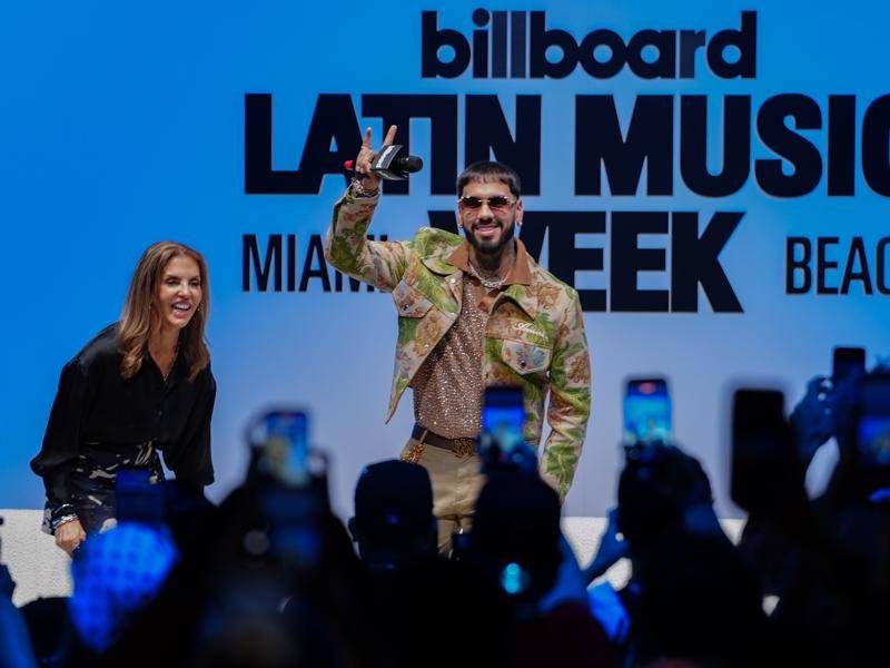 El cantante puertorriqueño Anuel AA saluda junto a la directora de contenido latino y en español de Billboard, Leila Cobo, durante el segundo día de la Semana Billboard de la Música Latina este martes, en el Teatro del Faena Forum en Miami Beach (Estados Unidos).