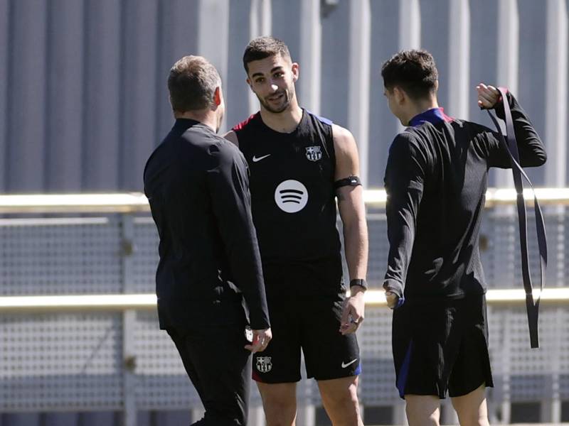 Los jugadores del FC Barcelona Pedri y Ferrán Torres (c) conversan con el entrenador, Hansi Flick, durante el entrenamiento del equipo azulgrana, este sábado, en Sant Joan d'Espi, en preparación al partido de liga contra el Girona este domingo.