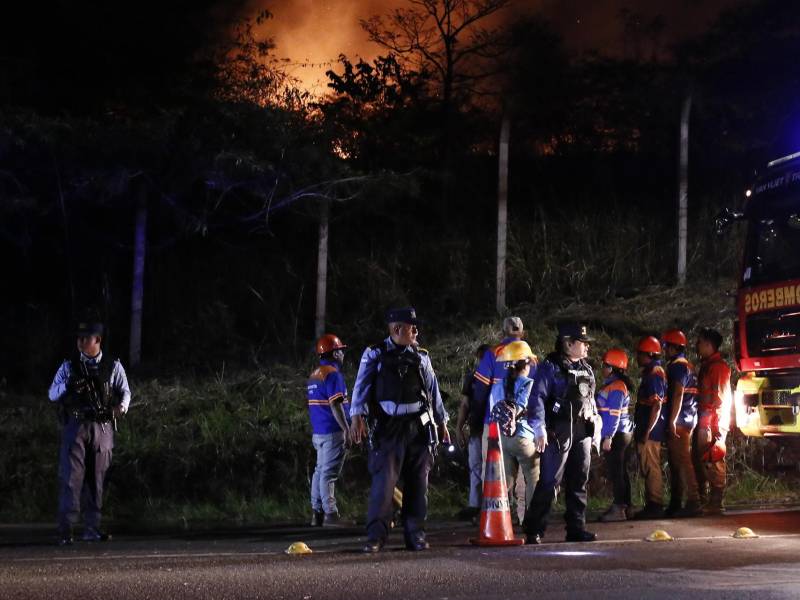 Bomberos hondureños trabajan junto a integrantes de la Policía de Honduras en la zona donde ocurrió un incendio forestal.