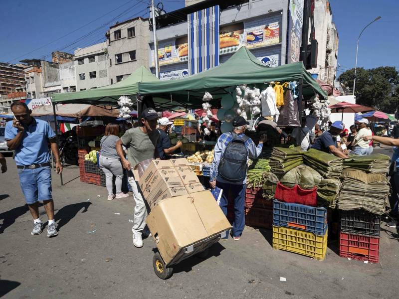 Una persona carga alimentos en una carreta en el mercado de Quinta Crespo el 22 de diciembre de 2025, en Caracas.