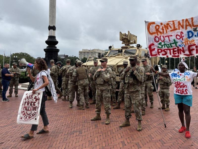 Un grupo de personas protesta frente a un escuadrón de la Guardia Nacional de EEUU por su despliegue en Washington DC.