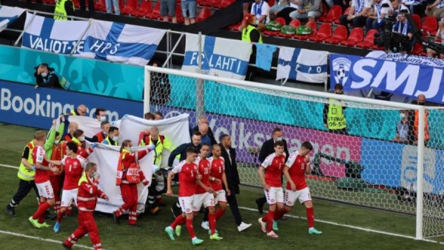 $!Players escort paramedics as Denmark's midfielder Christian Eriksen is evacuated from the pitch during the UEFA EURO 2020 Group B football match between Denmark and Finland at the Parken Stadium in Copenhagen on June 12, 2021. (Photo by WOLFGANG RATTAY / various sources / AFP)