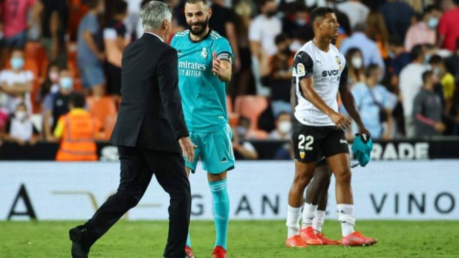 $!Real Madrid's Italian coach Carlo Ancelotti (L) and Real Madrid's French forward Karim Benzema celebrate their win at the end of the Spanish League football match between Valencia CF and Real Madrid CF at the Mestalla stadium in Valencia on September 19, 2021. (Photo by JOSE JORDAN / AFP)