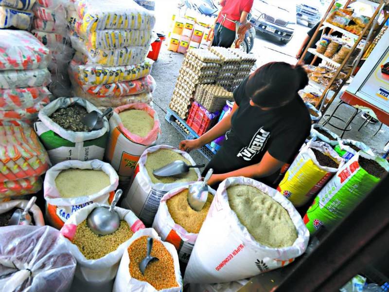 Una mujer vende alimentos básicos en un mercado de San Pedro Sula.