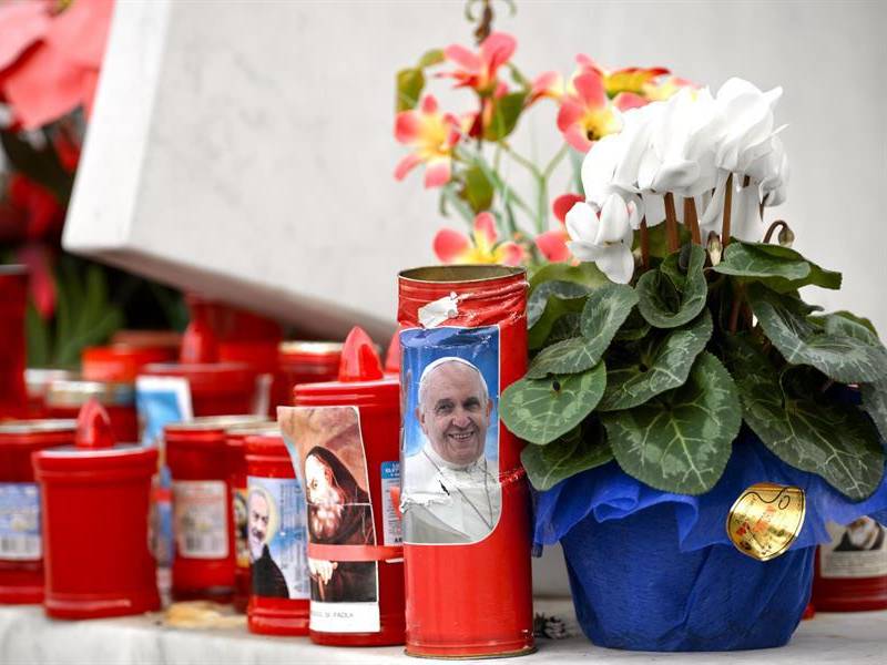 Los fieles en el Vaticano dejan velas y flores pidiendo por la recuperación del Papa.