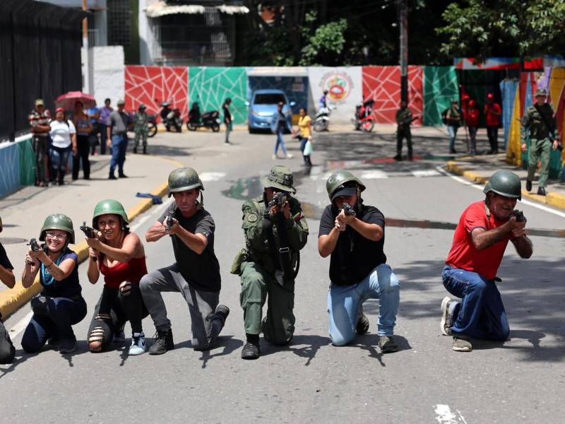 Personas apuntan con armas durante instrucciones militares por parte de la Fuerza Armada Nacional Bolivariana (FANB) de Venezuela el sábado, en Caracas.
