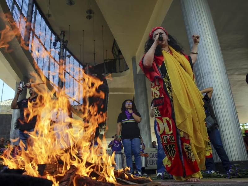 Una mujer habla junto a una fogata durante una manifestación en el marco del Día Internacional de la Mujer este viernes, frente al Parlamento en Tegucigalpa (Honduras).