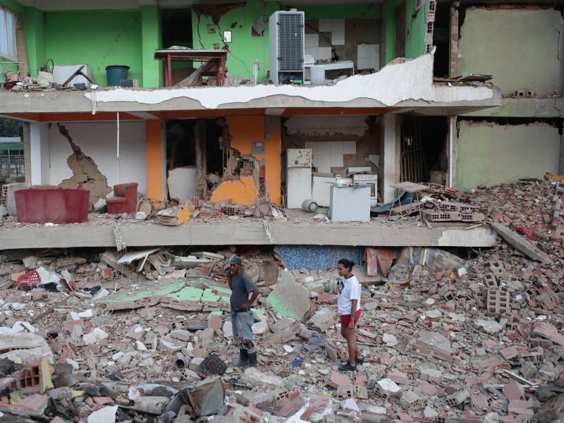 Dos residentes entre los escombros de uno de los bloques de viviendas derrumbado por los terremotos en la localidad de Catia La Mar, en el estado costero de La Guaira (Venezuela) este jueves. EFE/ Ronald Pena R.