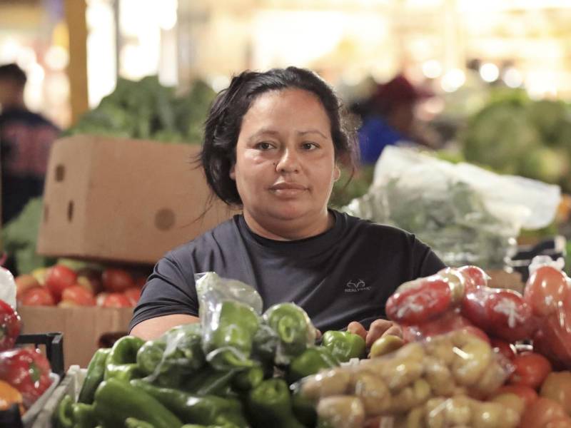 Libni Castejón trabaja en su puesto de venta de verduras en la feria del agricultor y el artesano el 22 de diciembre de 2025, en Tegucigalpa.