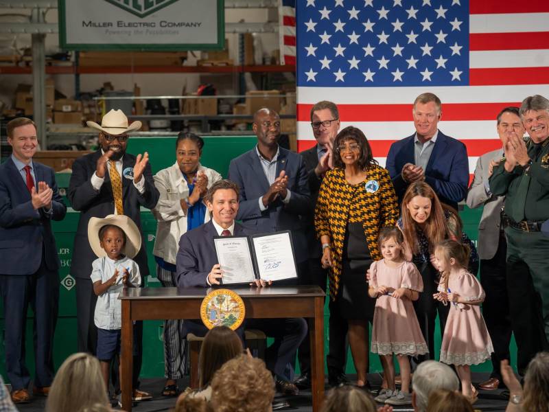El Gobernador Ron DeSantis muestra la proclamación de la ley de inmigración tras su firma en Jacksonville, Florida.