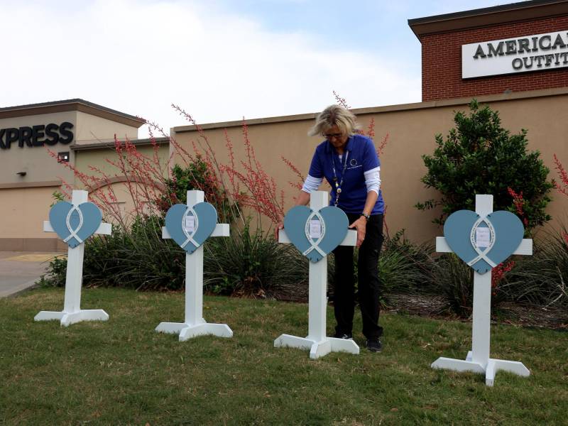 Voluntarios colocan un memorial en las afueras del centro comercial donde murieron ocho personas durante un tiroteo en Texas.