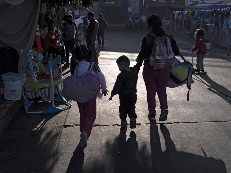 Una familia llega a un improvisado campamento de migrantes en Tijuana. EEUU inició hoy a devolver los solicitantes de asilo a México.