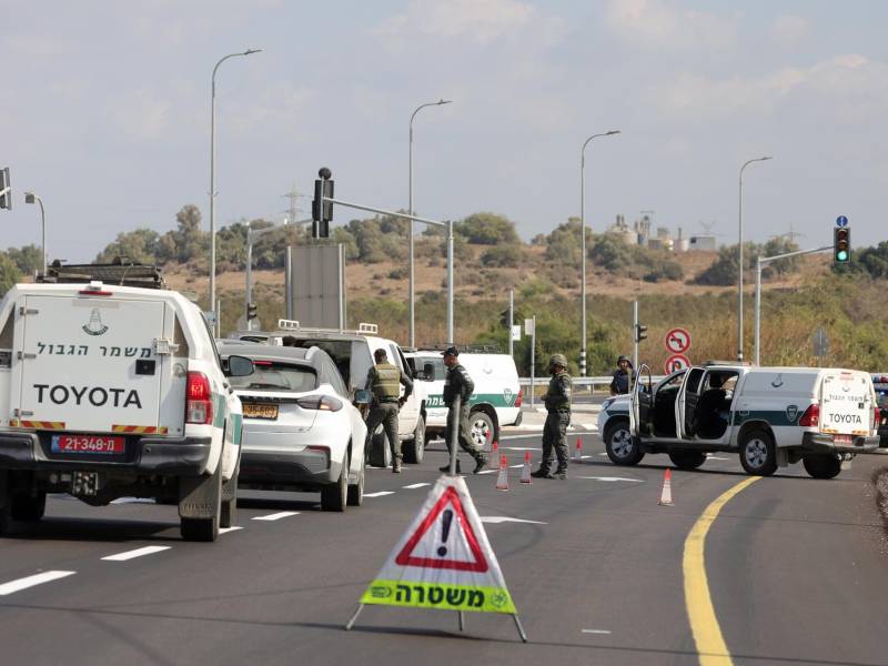 Miembros de la policía israelí controlan vehículos en un control de carretera cerca de Ashkelon tras el lanzamiento de cohetes desde Gaza.