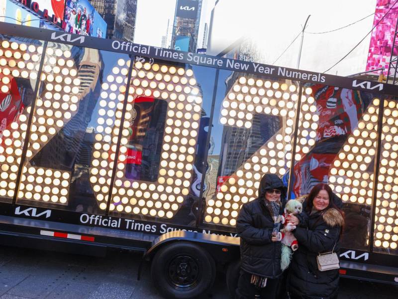 Dos personas posan para fotos frente a los números de siete pies de altura '2024', que se colocarán en la cima de One Times Square para la celebración del Año Nuevo, hoy, en Nueva York.