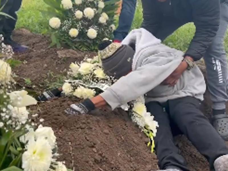 El padre de la niña hondureña llora cuando está siendo sepultada.