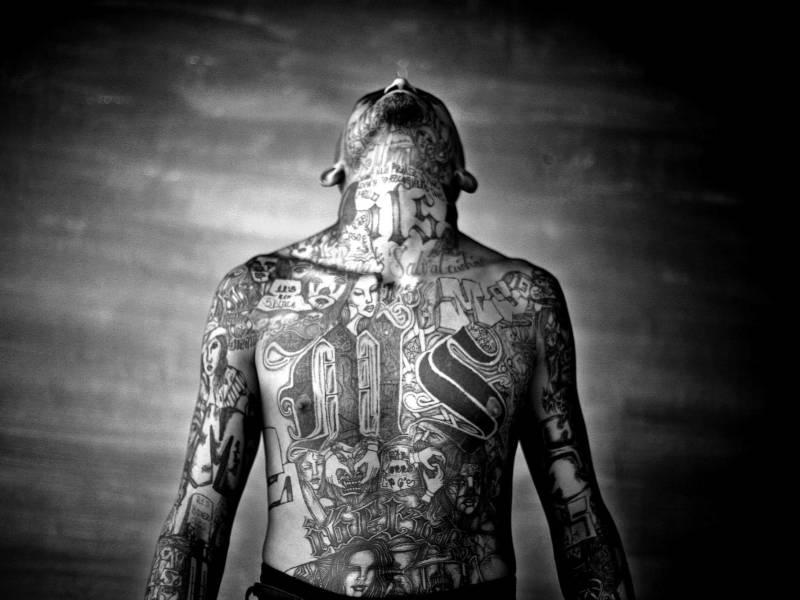 Un miembro de la Mara Salvatrucha con tatuajes representativos en su cuerpo.