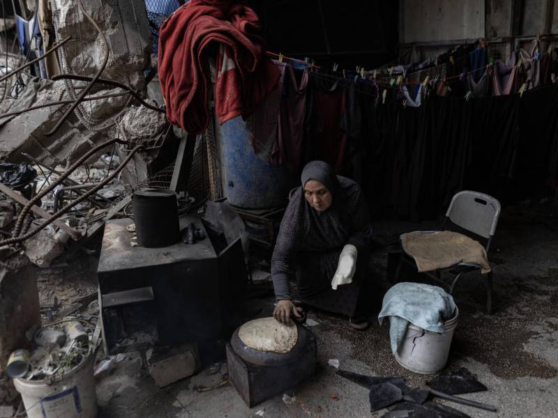 En Gaza, un saco de harina que valía unos 5 dólares antes de la guerra ahora cuesta 300 dólares. Una mujer prepara pan.