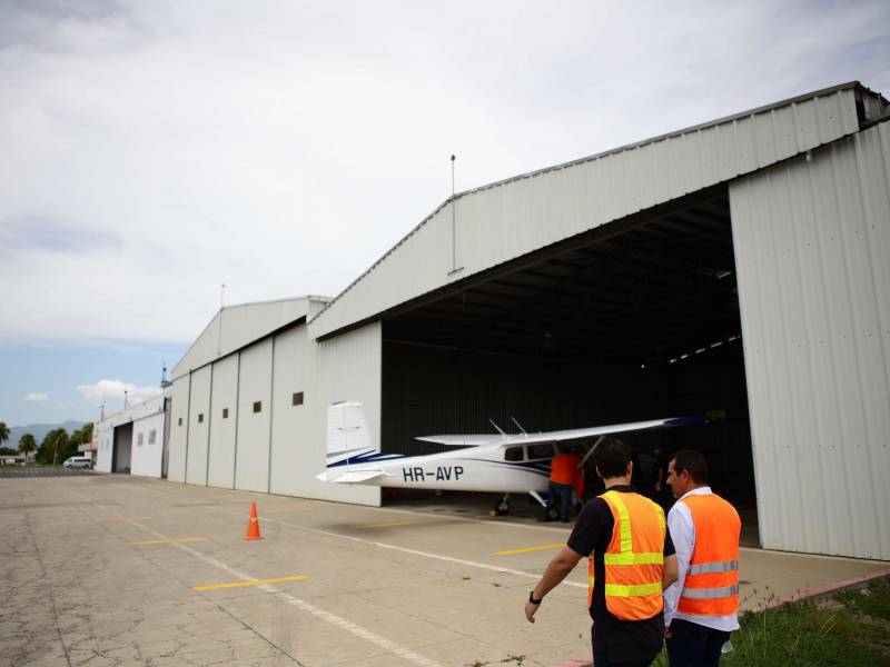 Dos pilotos hacen un recorrido por los hangares restaurados por el Aeroclub San Pedro Sula.