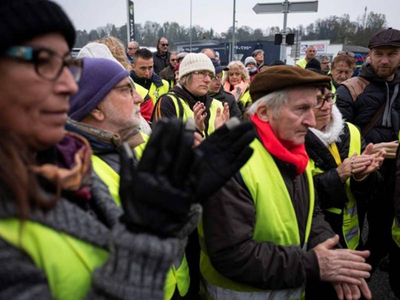 Miembros del movimiento 'chaleco amarillo' (gilets jaunes) aplauden durante una manifestación en homenaje a Chantal Mazet, un año después de la muerte de la mujer de 63 años en una rotonda en Le Pont-de-Beauvoisin.