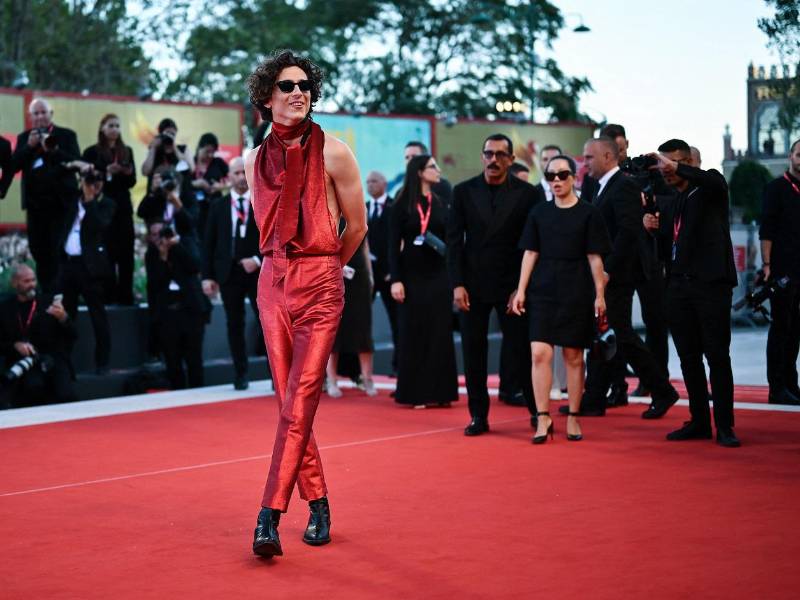 El actor estadounidense Timothée Chalamet desató la locura entre cientos de personas a su paso por la alfombra roja del Festival de Venecia, donde apareció con un entallado traje del mismo color y la espalda al descubierto para presentar su última película, “Bones and all”.