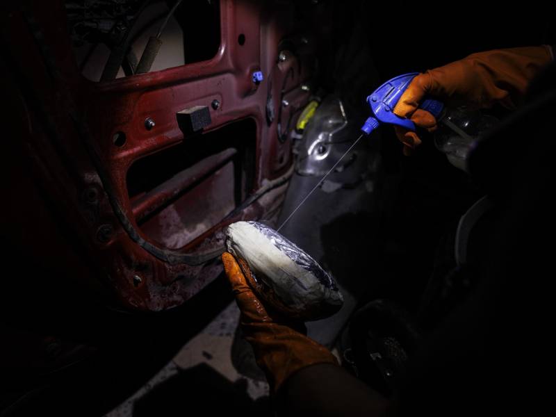 Un paquete es rociado con un líquido de sustancias químicas que ayudan a disimular el potente olor a fentanilo.