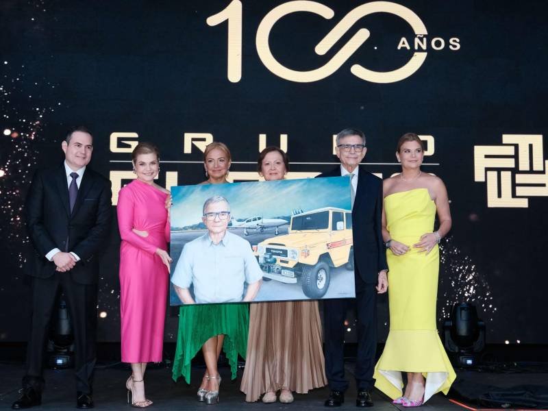 Grupo Flores realizó un magno evento, en el cual festejó 100 años de servir al pueblo hondureño. La celebración tuvo lugar en el Centro de Convenciones del Hotel Copantl, lugar que se escogió para rendir homenaje a la trayectoria que esta empresa hondureña ha logrado gracias a clientes, colaboradores, socios estratégicos y la familia Flores. El evento estuvo cargado de emociones positivas, se entregaron reconocimientos a Alan E. Flores, actual presidente de la compañía. Además, se contó con la presencia de Masahiro Inoue, CEO de Toyota para América Latina y el Caribe. En la postal, los hijos de Alan E. Flores le hacen entrega de un cuadro significativo a su querido padre, guía y soporte de su camino en esta vida.