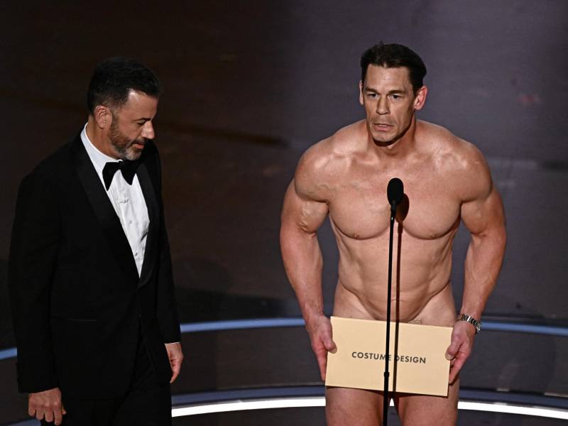 El 16 veces campeón mundial de lucha libre en la WWF y actor de cine norteamericano, John Cena, protagonizó uno de los momentos más inesperados y divertidos de la gala de premios de los premios Óscar 2024. Cena se apareció en el escenario “desnudo”, para presentar a los nominados en la categoría a Mejor Diseño de Vestuario. Jimmy Kimmel, el anfitrión de los premios, lo “persuadió” para salir en ese estado con un propósito.