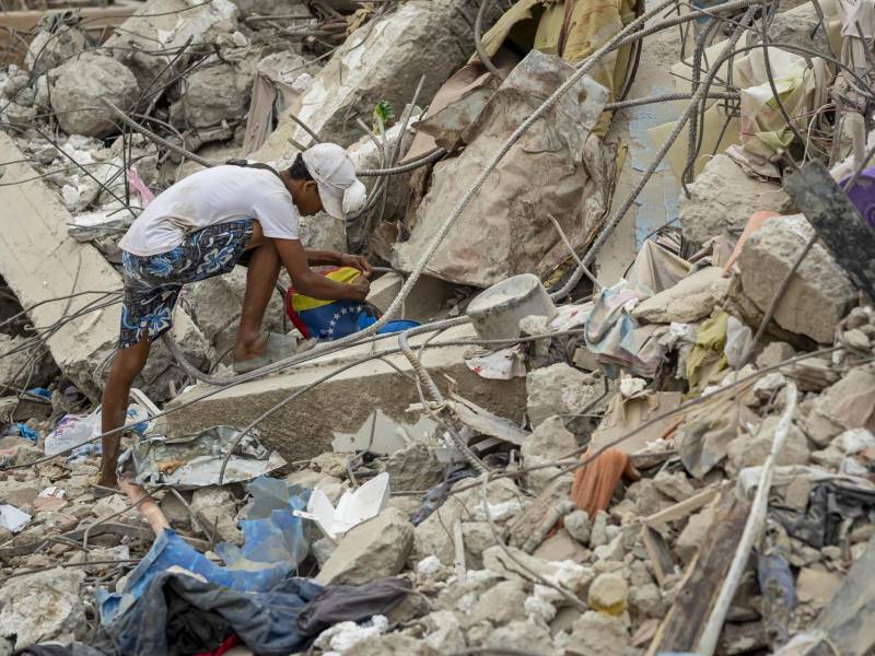 Una persona busca entre los escombros de edificios destruidos por terremotos en Caraballeda (Venezuela). EFE/ Miguel Gutiérrez