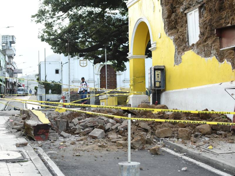 Una persona camina cerca de los escombros ocasionados tras los sismos en Guatemala.