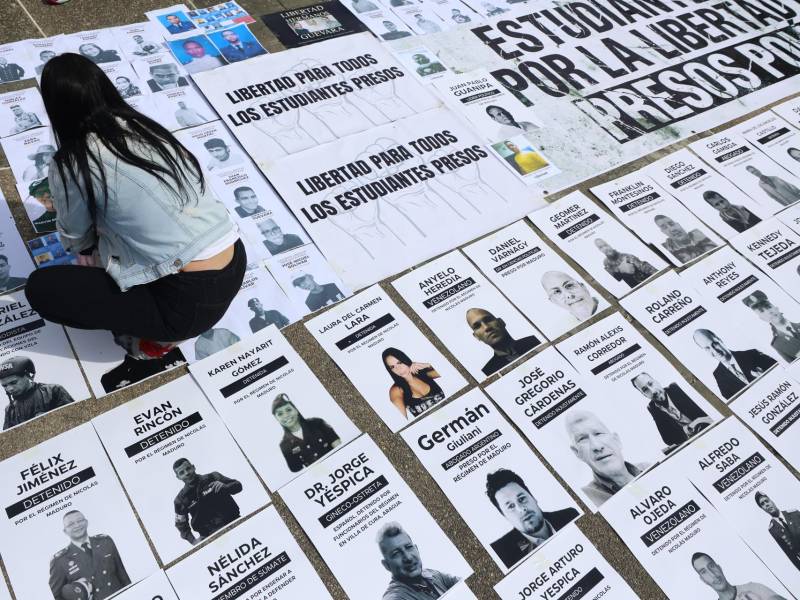 Una persona organiza carteles con imágenes de presos políticos este martes, en la Plaza del Rectorado UCV, en Caracas, Venezuela.