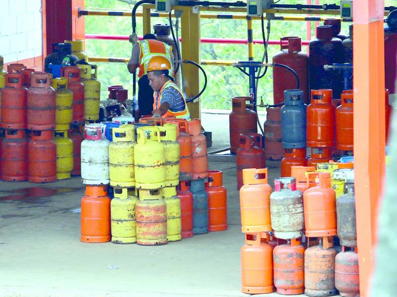 Trabajadores en una planta de GLP llenan cilindros de este combustible usado en las cocinas de Honduras