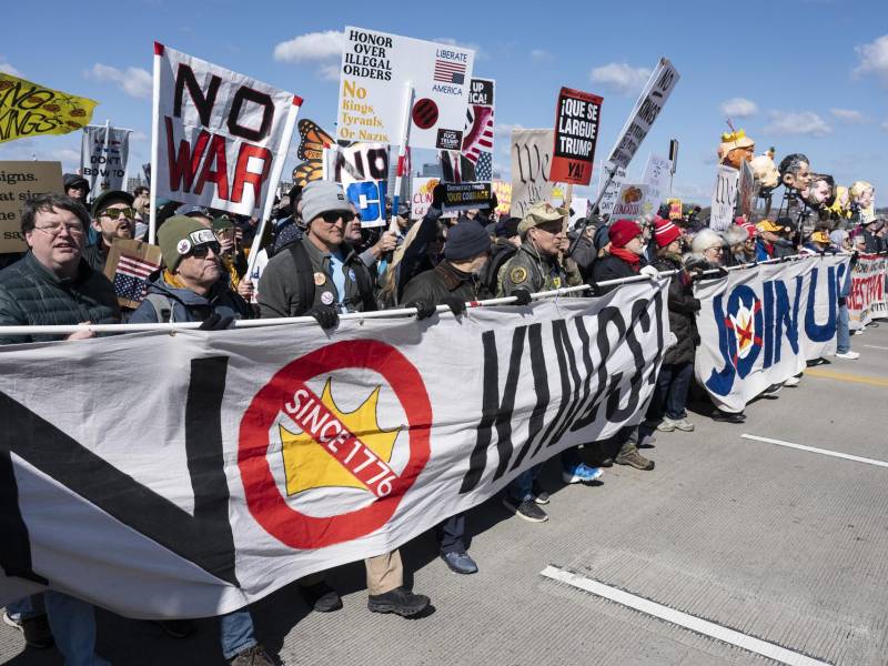 Activistas sostienen carteles y pancartas mientras participan en la marcha 'No Kings' (No reyes) en Washington.