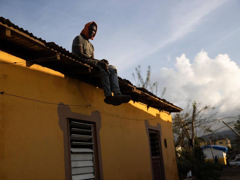 Una persona observa desde el techo de una casa afectada por el paso del huracán Melissa este jueves, en Santa Cruz (Jamaica). Cuba, Jamaica, Haití y Bahamas comenzaron este jueves a evaluar daños tras el calamitoso paso del huracán Melissa, uno de los más dañinos en los últimos años, que destruyó viviendas e infraestructuras y dejó más de una treintena de muertos. EFE/ Orlando Barría