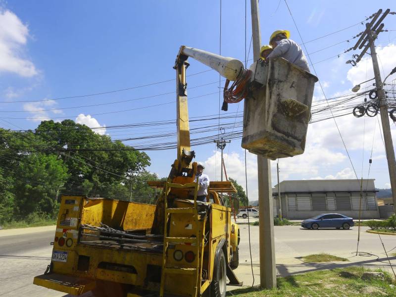 Cuadrillas de la Enee instalan cableado en el bulevar hacia el sector Los Carmenes.