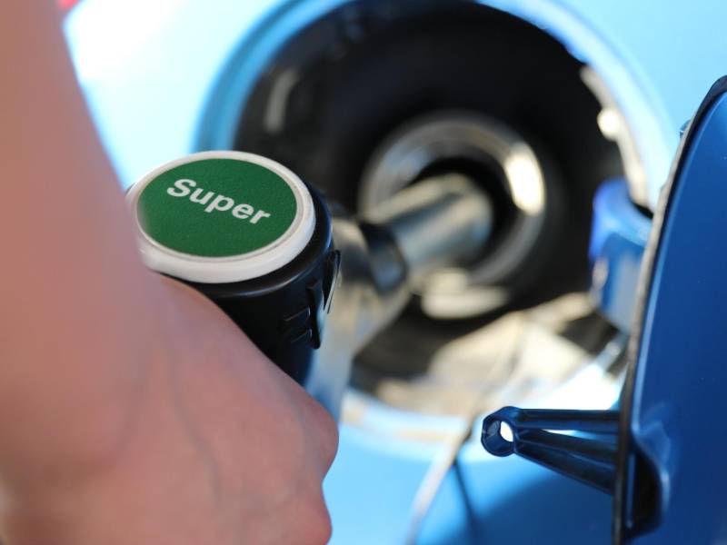 Una persona carga gasolina superior en una estación de servicio.