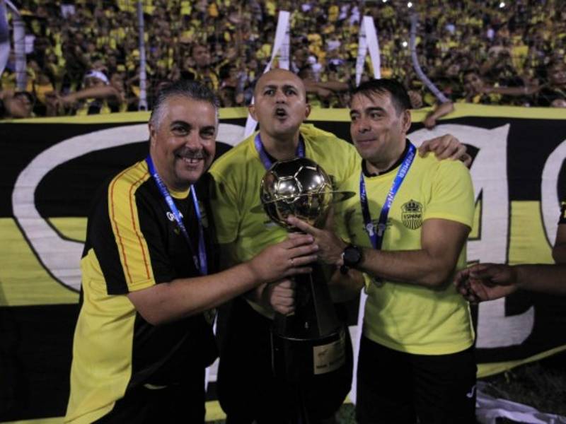 El entrenador Ramiro Martínez festeja con la Copa tras imponerse al Olimpia.